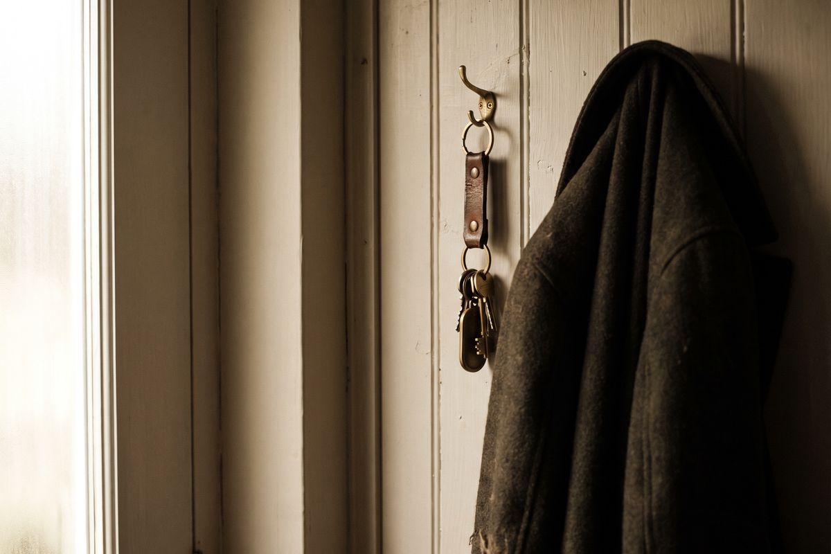 A set of van keys hanging on a hook beside a front door.
